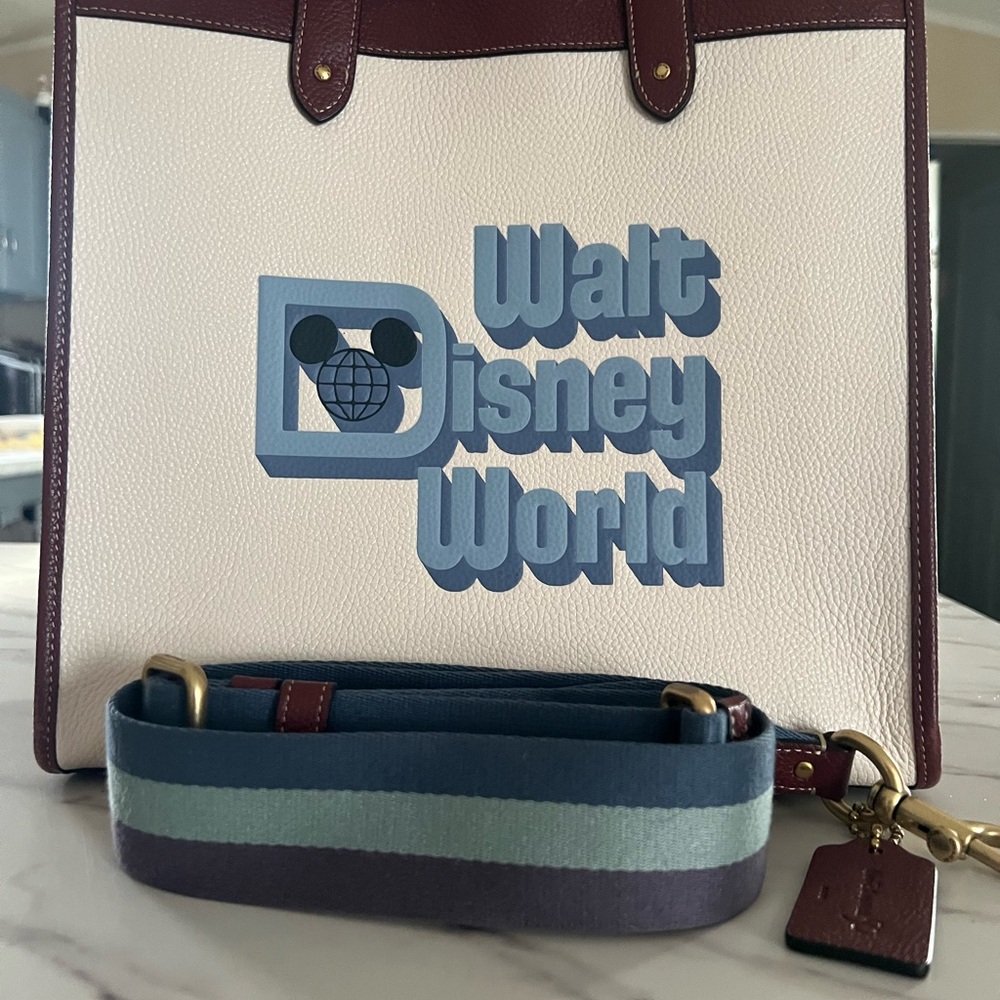 COACH Disney Cream Tote with Blue Logo and Burgundy Trim.